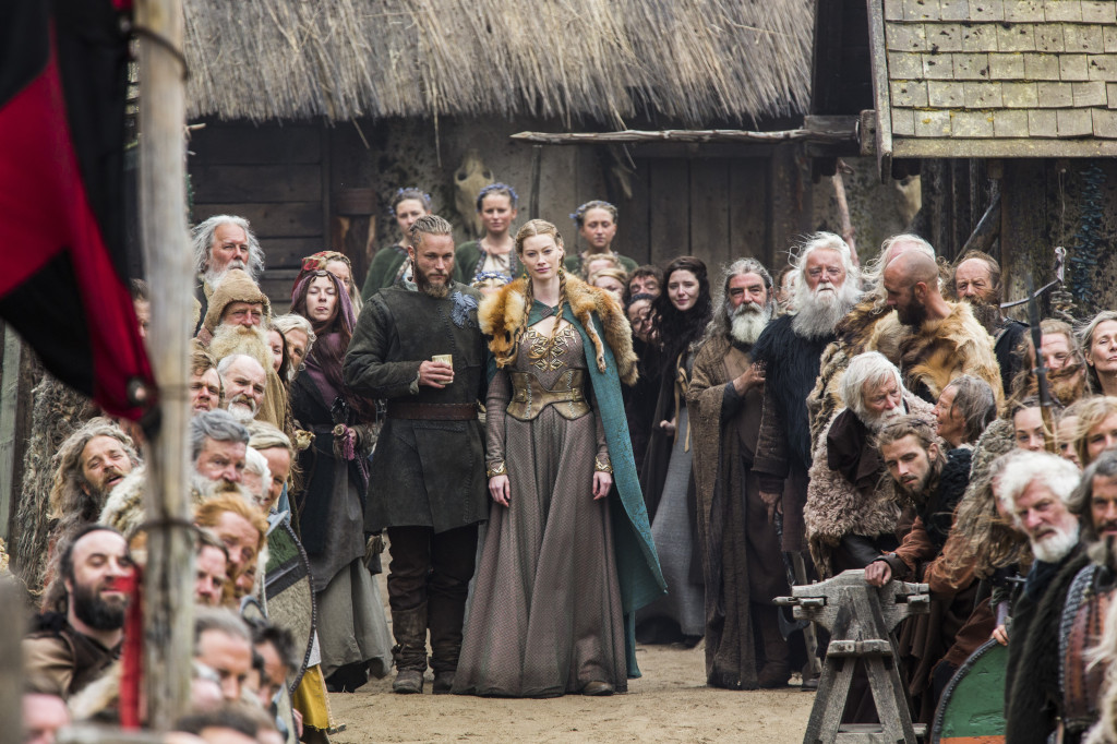 Earl Ragnar (Travis Fimmel) and Princess Aslaug (Alyssa Sutherland) surrounded by the people of Kattegat